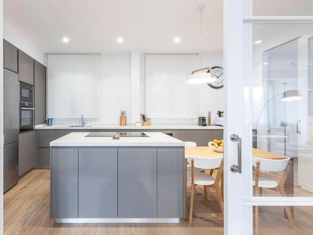 Cocina con isla central y mesa de comedor.